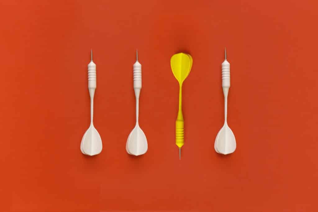 Darts on a red background. Top view. Flat lay.