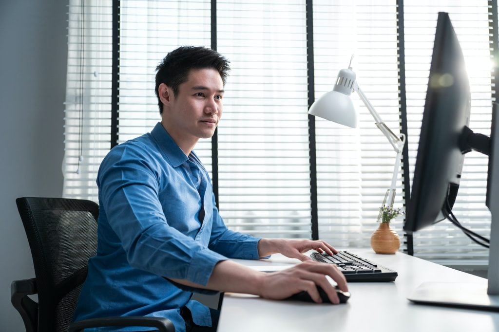 Asian handsome business man using laptop computer working in office.