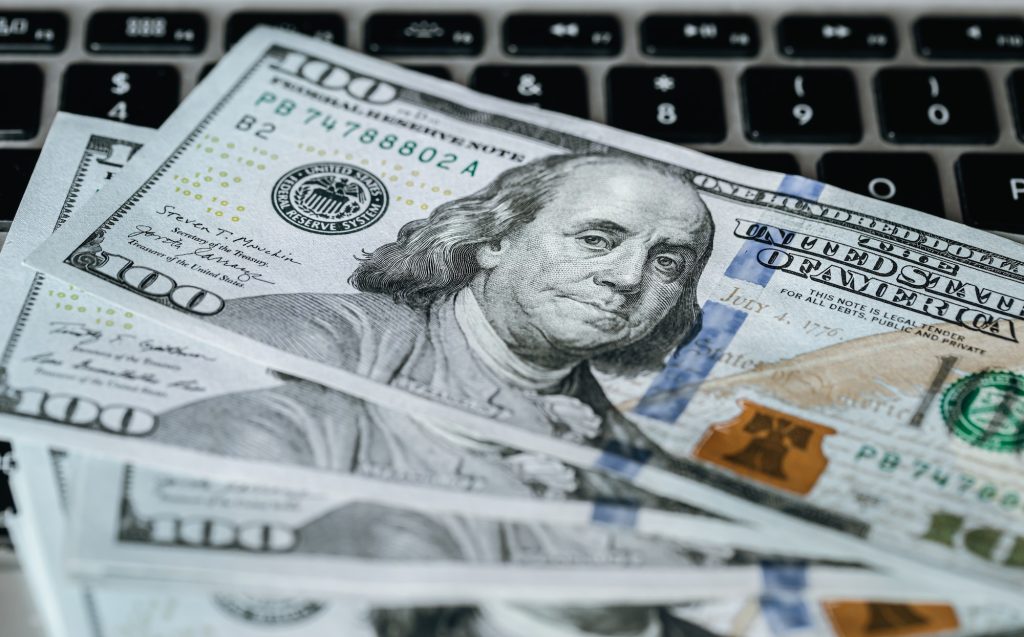 Close up, dollar bills on laptop, money making concept.