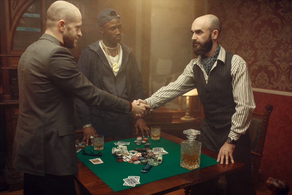 Male poker players shake hands in casino