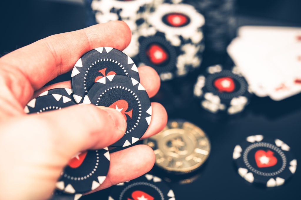 Black Poker Chips in Player’s Hand