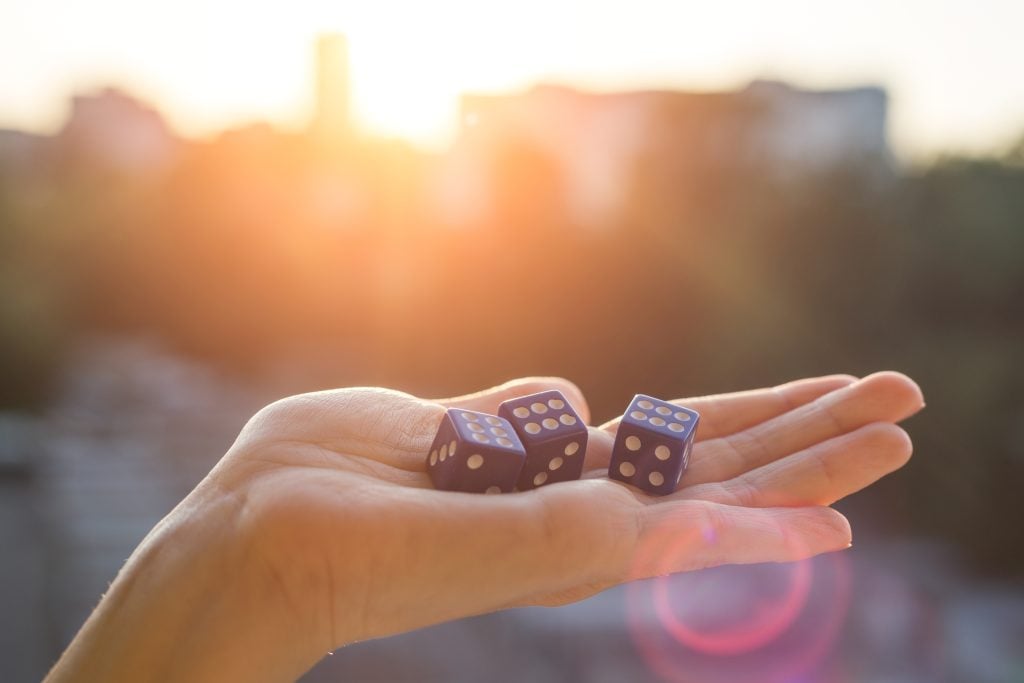 Cubes with number 6 in hand sunset background