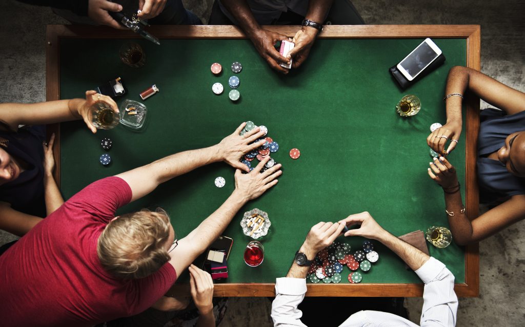 Diverse group playing poker and socialising