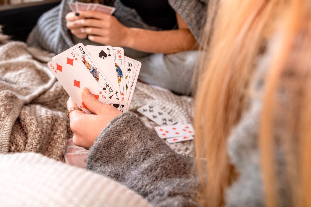hands of people playing cards at home, selective focus, focus on cards