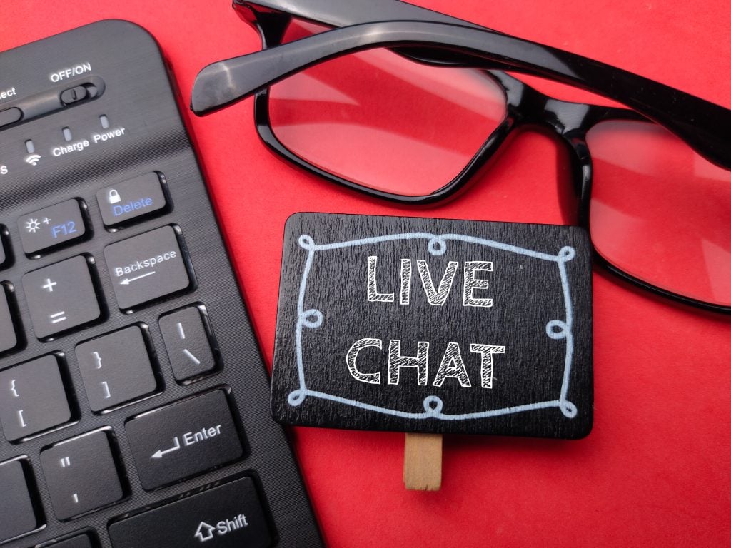 Keyboard and glasses with the word LIVE CHAT
