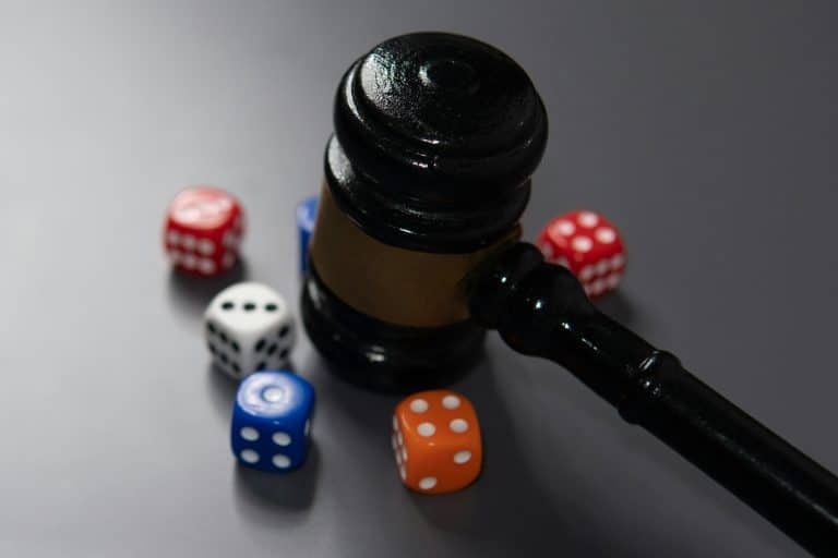 Closeup image of judge's gavel and a handful of scattered dice.