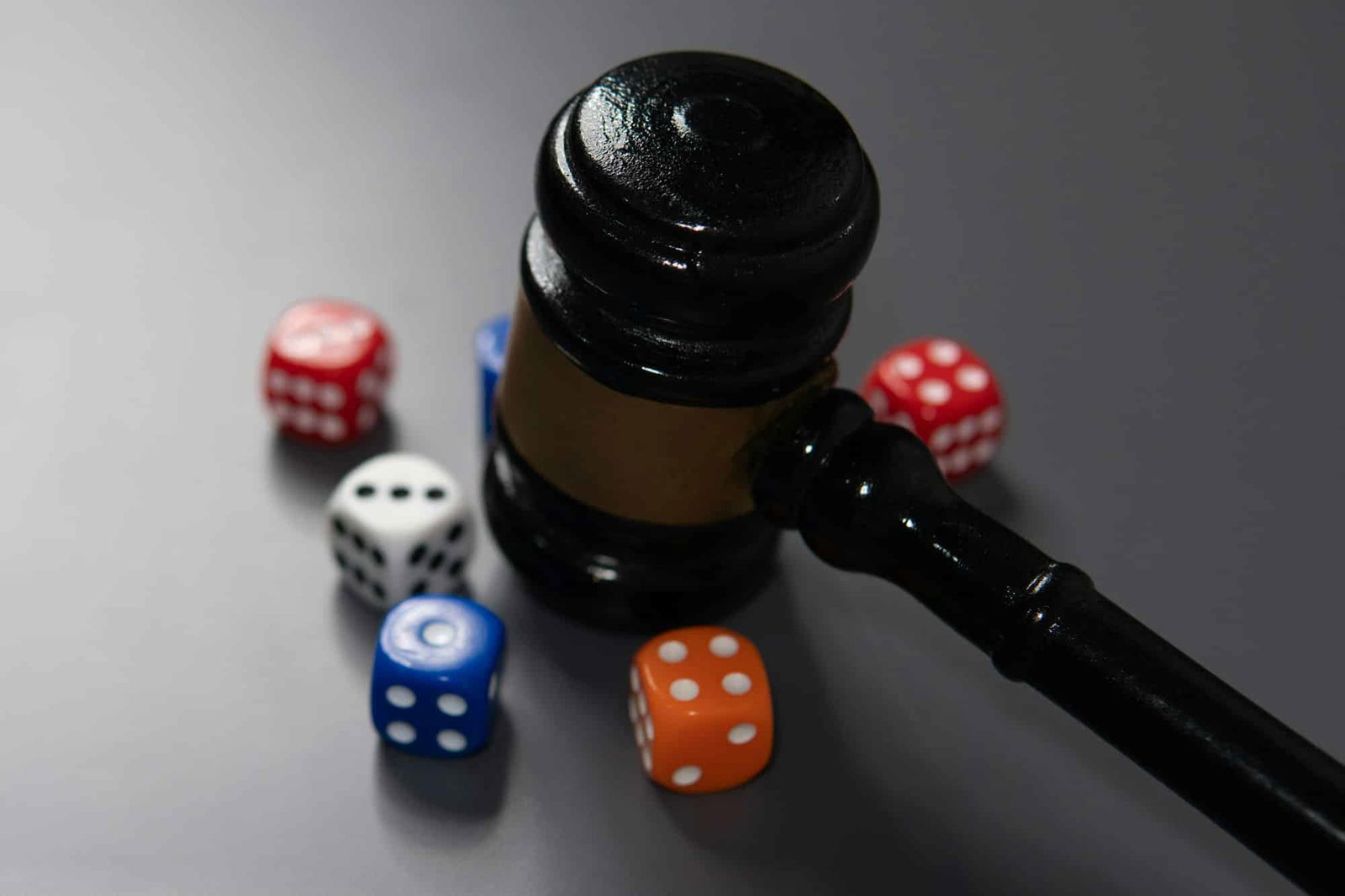 Closeup image of judge's gavel and a handful of scattered dice.