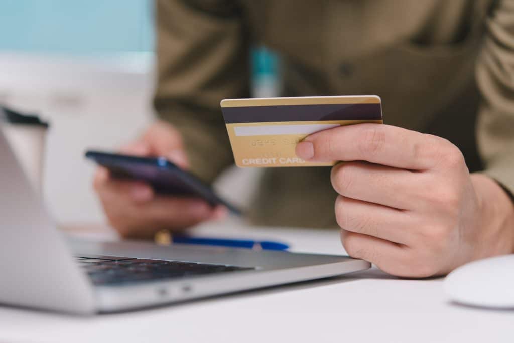 online payment internet hand holding card credit transaction with computer laptop